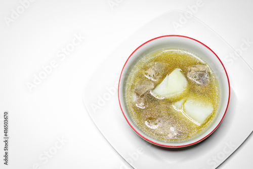Pork rib soup and potato in white bowl on white background.