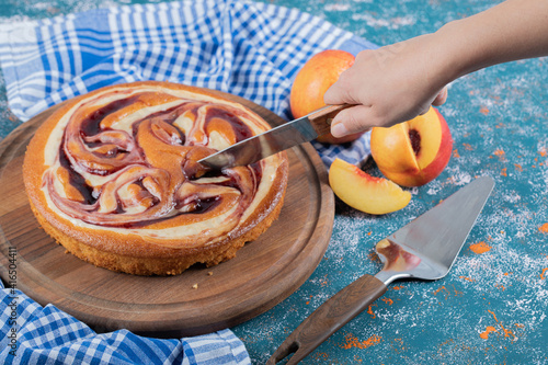 Cutting a slice of strawberry cake on a wooden baord photo