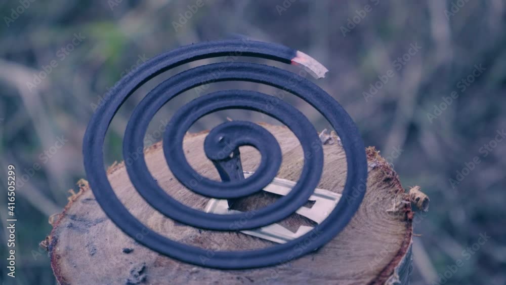Mosquito coil lies on a stump smoldering and smoking Mosquito coil lies on a stump smoldering and smoking