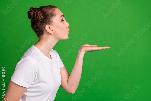 Profile photo of lovely lady hold palm blow air kiss look empty space wear white t-shirt isolated green background