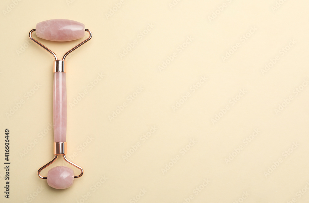 Natural face roller on beige background, top view. Space for text Natural face roller on beige background, top view. Space for text