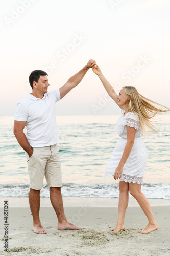 happy couple hugging on the seashore at sunset of the day. summer romance of lovers. walk near the sea. newlyweds on honeymoon. romantic time. happy young people.