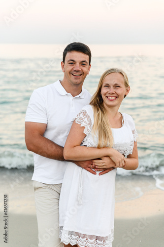 happy couple hugging on the seashore at sunset of the day. summer romance of lovers. walk near the sea. newlyweds on honeymoon. romantic time. happy young people. © Vadym