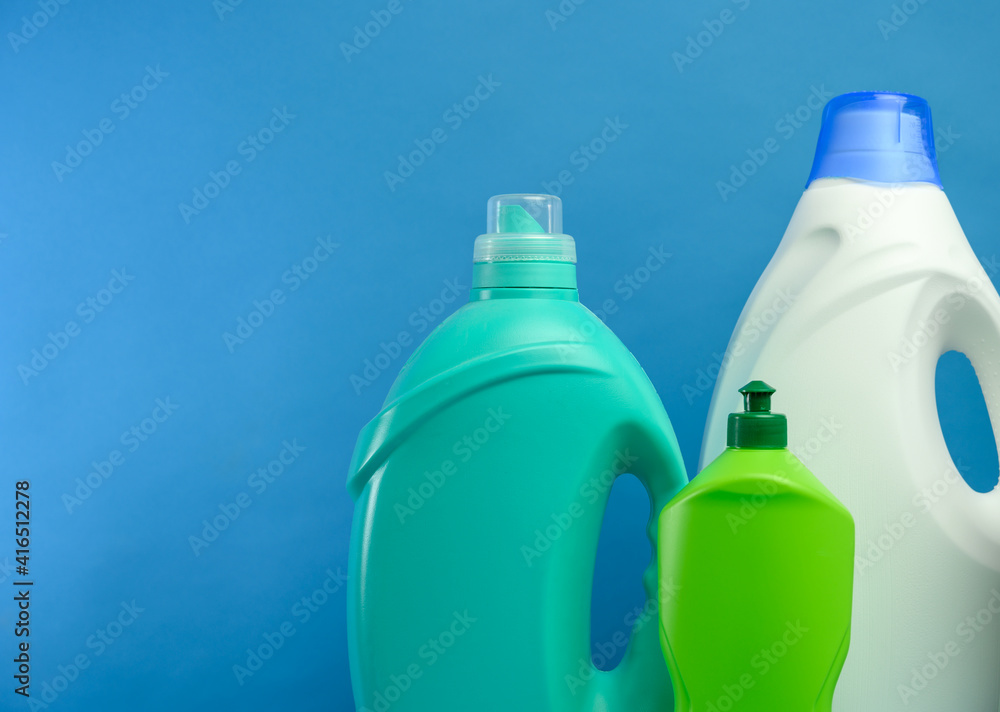 plastic bottles with detergents on blue background