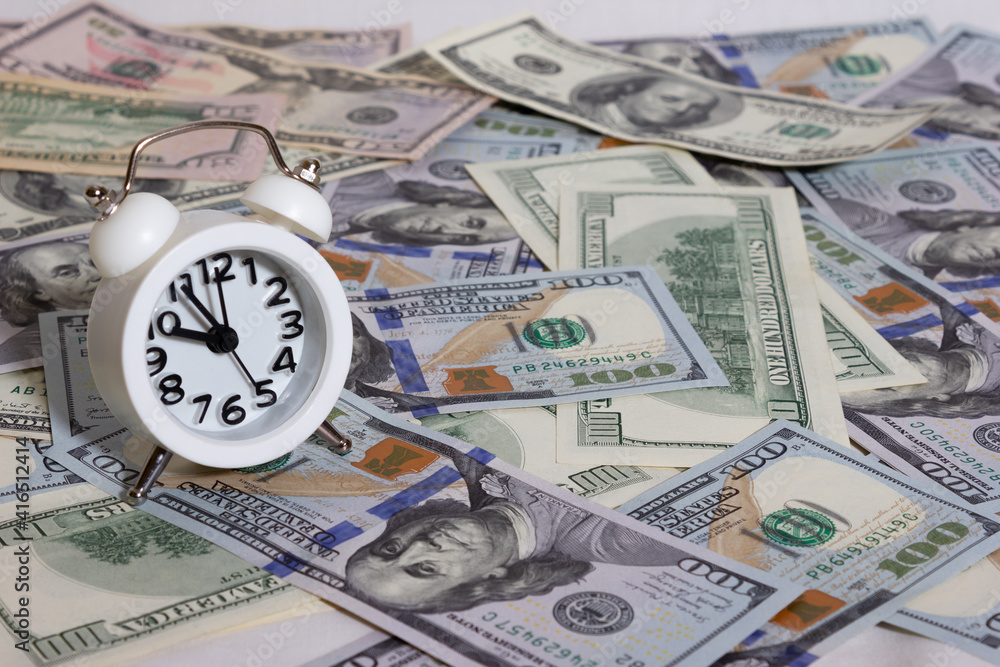 Clock on the background of bundle of dollars - texture, background Clock on the background of bundle of dollars - texture, background