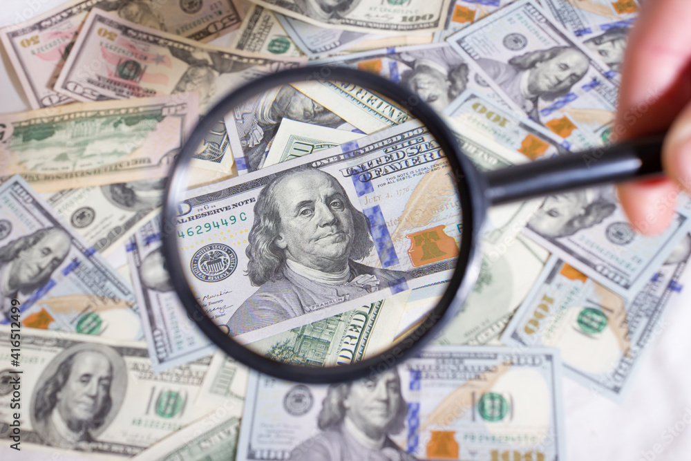 Magnifying glass on the background of bundle dollars - texture, background Magnifying glass on the background of bundle dollars - texture, background