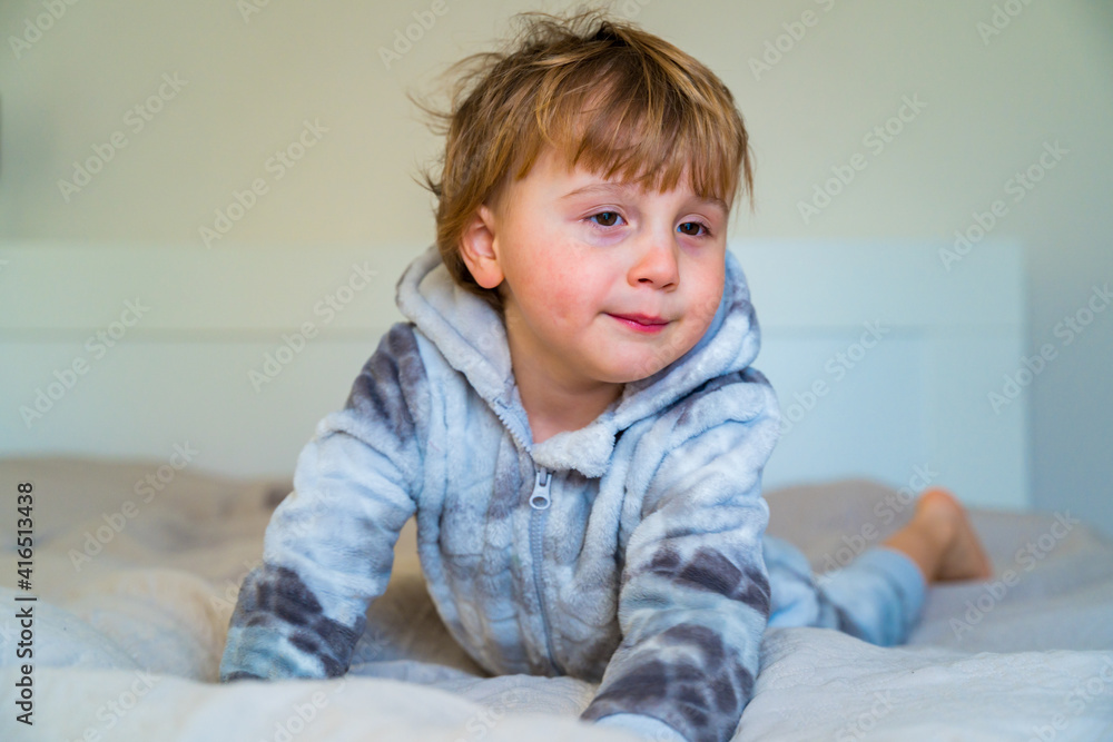 Little toddler waking up in the morning, lying in bed. Sleepy child at home. Little toddler waking up in the morning, lying in bed. Sleepy child at home.
