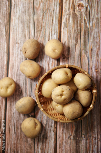 Fresh raw potatoes on a wooden background