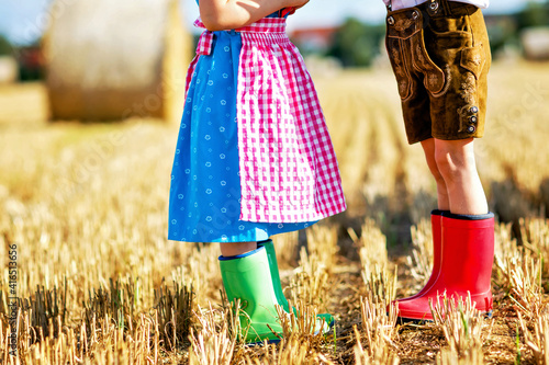Two kids in traditional Bavarian costumes and red and green rubb