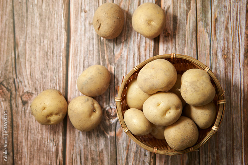 Fresh raw potatoes on a wooden background