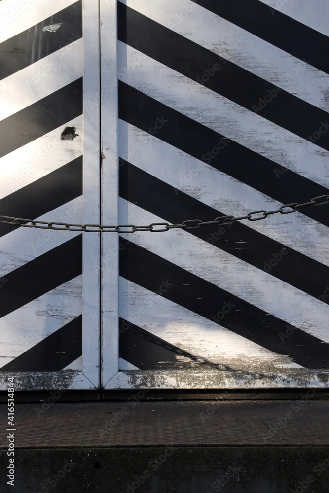 Fototapeta premium schwarz-weiss diagonal gestreifte tür detail mit kette