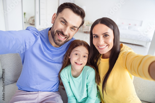 Photo of cheerful family mom dad daughter happy positive smile make selfie record video sit sofa home