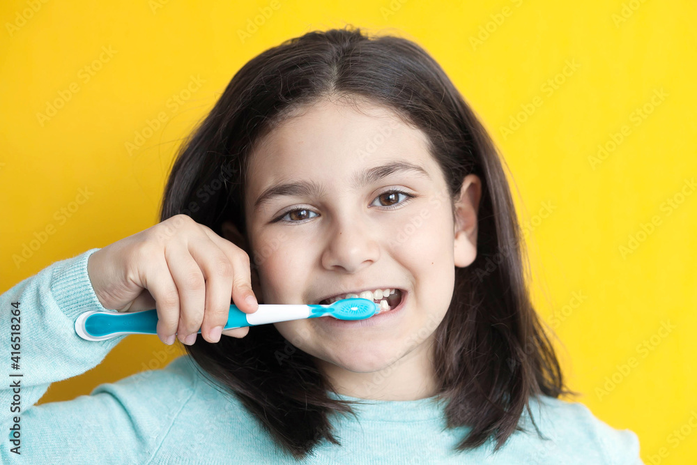 Little cute child girl brushing her teeth on white background. Space for text. Healthy teeth. Little cute child girl brushing her teeth on white background. Space for text. Healthy teeth.