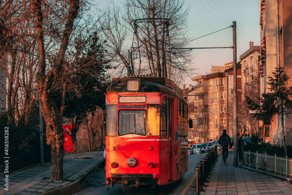 Obraz premium Old nostalgic tram going through the streets of Kadikoy on the Asian side of Istanbul. Sunset view. 