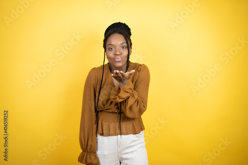 African american woman wearing casual clothes looking at the camera blowing a kiss with hand on air being lovely and sexy. Love expression. © Irene