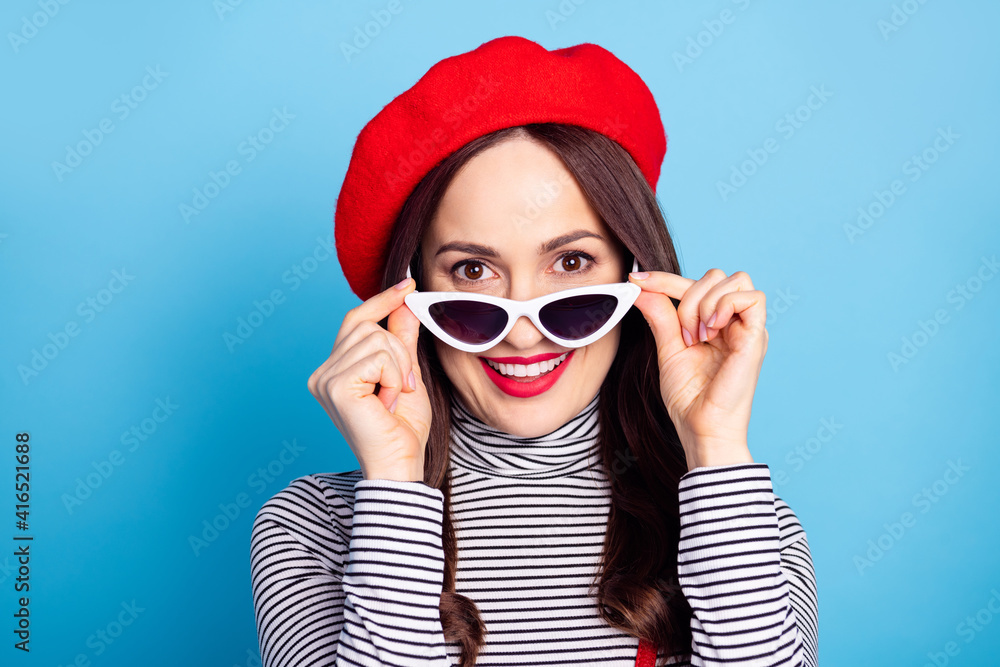 Photo portrait of pretty girl surprised taking off sunglass wearing red beret turtleneck isolated bright blue color background Photo portrait of pretty girl surprised taking off sunglass wearing red beret turtleneck isolated bright blue color background