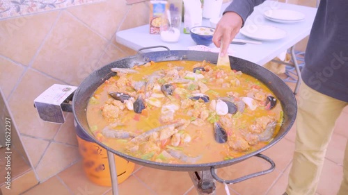 Preparing a homemade spanish paella on a large gas stove photo