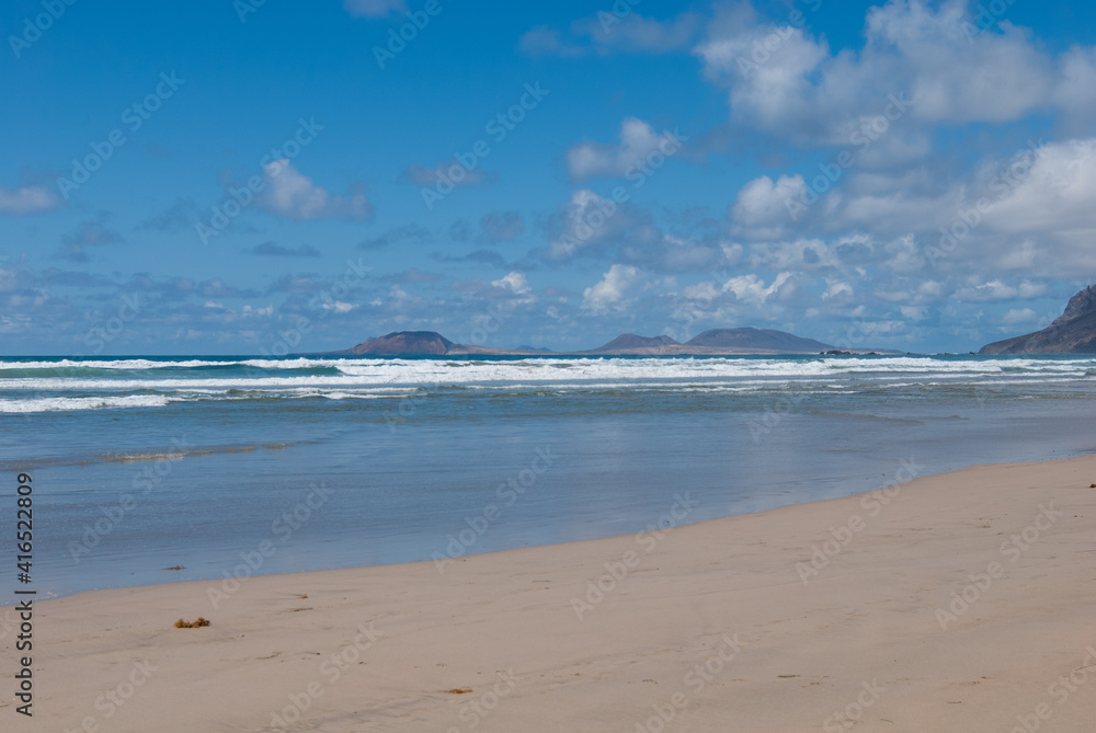 Weite und Einsamkeit am Sandstrand vom Famara, im Hintergrund die Insel La Graciosa