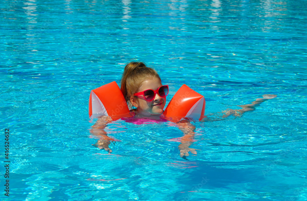  Little girl in swimming pool . Kids learn to swim.