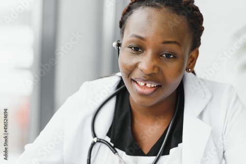 Closeup portrait of friendly, smiling confident female healthcare professional with lab coat, stethoscope, arms crossed. Isolated hospital clinic background. Time for an office visit