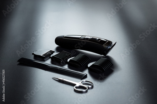 Electric shaving trimmer kit. Shaving machine on black. Barber tools on black with light on it. photo