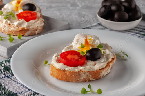 Bruschetta with tomato, olives and poached quail egg