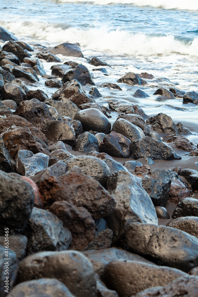 Boulders, stones and various rocks worn by water, of volcanic origin, on the beach of Nogales, in the northeast of the island of La Palma, Canary Islands, Spain. Boulders, stones and various rocks worn by water, of volcanic origin, on the beach of Nogales, in the northeast of the island of La Palma, Canary Islands, Spain.