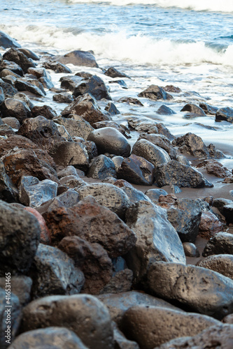 Boulders, stones and various rocks worn by water, of volcanic origin, on the beach of Nogales, in the northeast of the island of La Palma, Canary Islands, Spain.