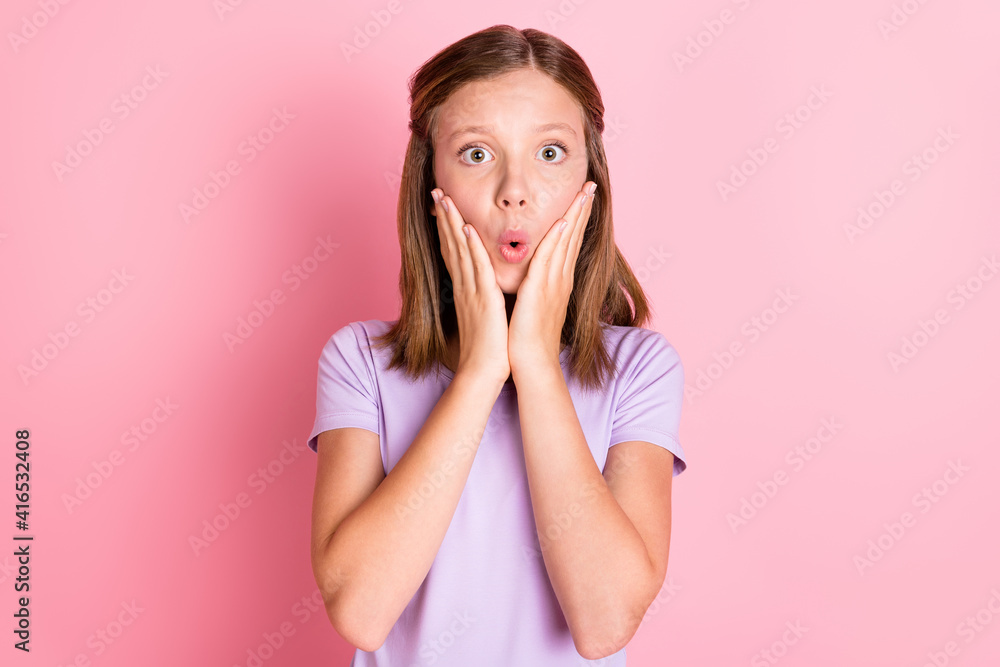 Photo of astonished shocked little teenage girl hold hands cheekbones isolated on pastel pink color background Photo of astonished shocked little teenage girl hold hands cheekbones isolated on pastel pink color background