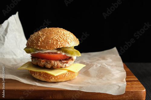 delicious homemade hamburger on wooden table and black background