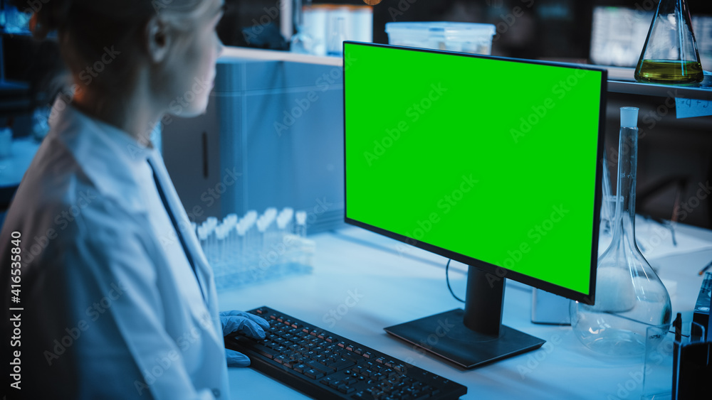 Medical Research Laboratory: Portrait of Female Scientist Working on Computer with Green Chroma Key Screen. Advanced Scientific Lab for Medicine, Biotechnology, Vaccine Development. Dark Blue Shot Medical Research Laboratory: Portrait of Female Scientist Working on Computer with Green Chroma Key Screen. Advanced Scientific Lab for Medicine, Biotechnology, Vaccine Development. Dark Blue Shot