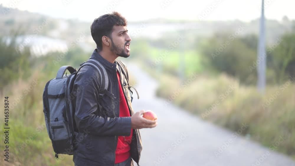 Portrait young male hiker eating apple. Tourist at foreston road and eat apple. fit man eating an apple outdoors in the woods. Caucasian man eating red apple outdoors, in lush public park. Portrait young male hiker eating apple. Tourist at foreston road and eat apple. fit man eating an apple outdoors in the woods. Caucasian man eating red apple outdoors, in lush public park.