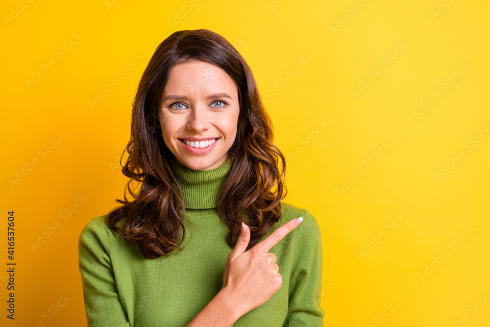 Portrait of young happy smiling cheerful good mood woman pointing finger copyspace isolated on yellow color background Portrait of young happy smiling cheerful good mood woman pointing finger copyspace isolated on yellow color background