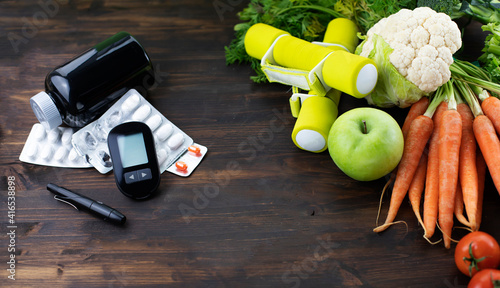 Glucose meter, pills, dumbbells and low glycemic healthy food. Diabetic diet and healthy life concept. photo