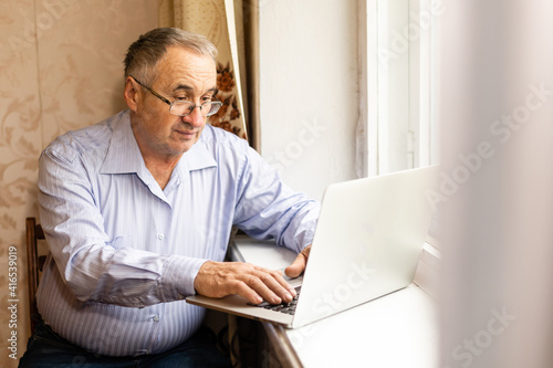 Senior working on a laptop at home