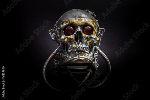 Spooky dark black skull aginast dark background photo