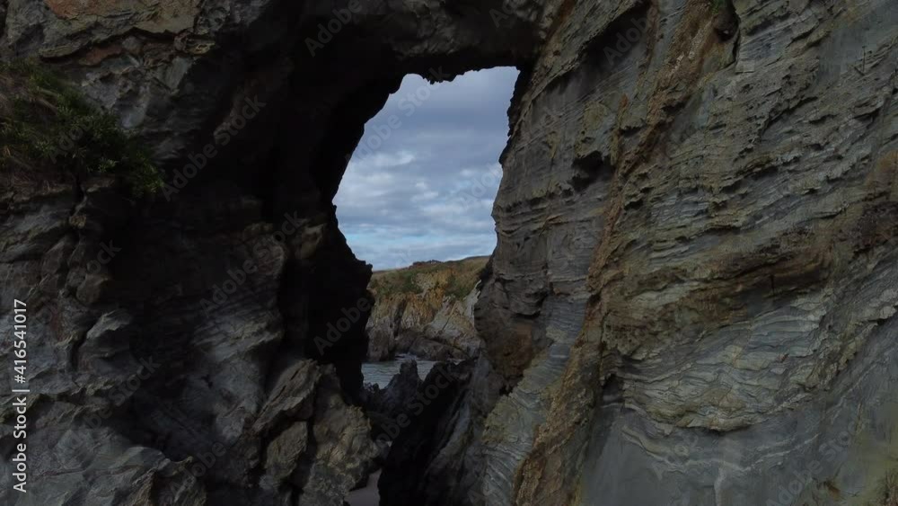 Entering a cave carved into the rocks of the coast.