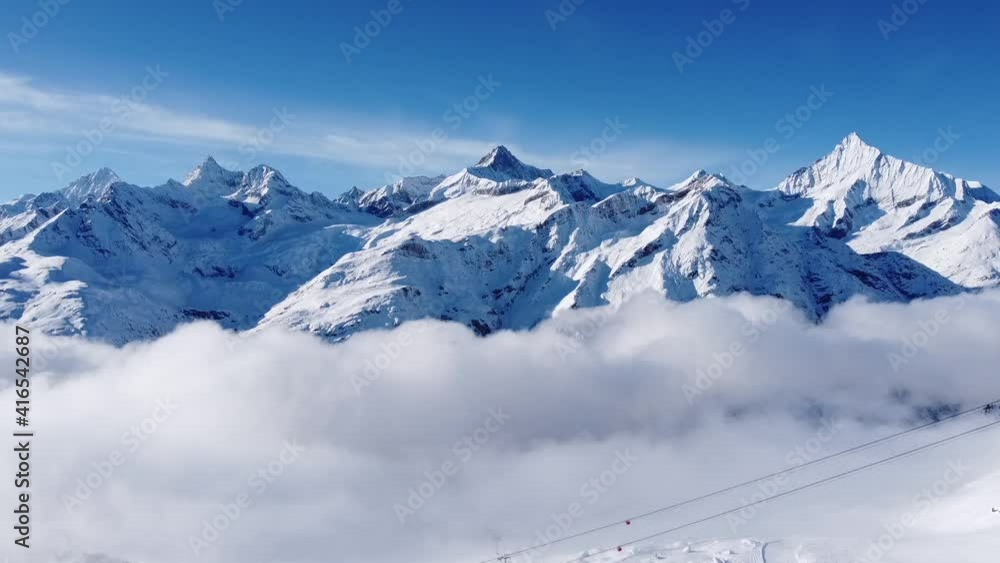 incredibly beautiful snow-covered mountains rise above the sea of ​​fog in switzerland