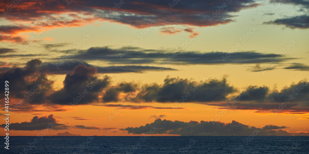 Panoramic view of the dark clouds on the sky after sunset over the ocean in the evening in Hawaii.