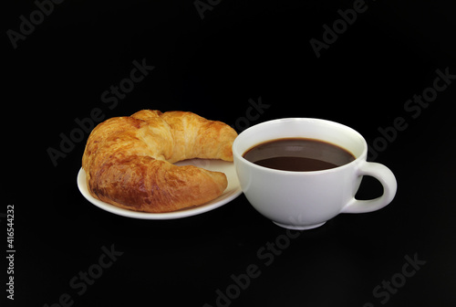 Fototapeta Naklejka Na Ścianę i Meble -  Croissants on a plate with a cup of espresso coffee isolated on black background