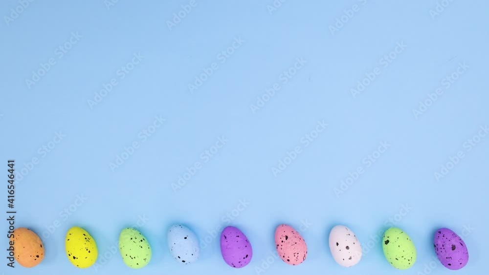 Easter eggs different colors move left right on bottom of blue theme. Stop motion Easter eggs different colors move left right on bottom of blue theme. Stop motion