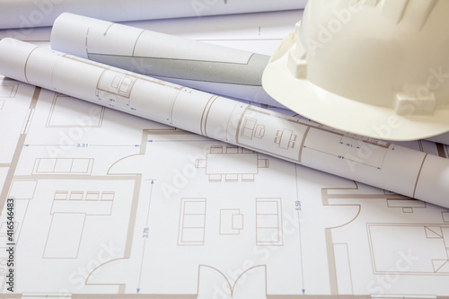 Construction concept. Residential building drawings and hardhat on an office desk