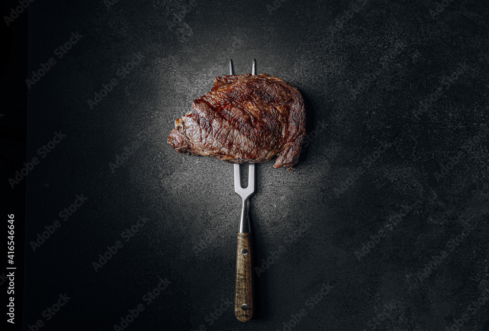 grilled beef steak on a dark background. expensive marbled beef of the highest grade fried to rare on the grill