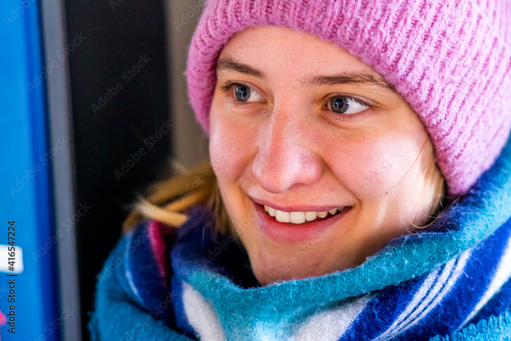 portrait of a young woman with cap and scalf smiling at the winter portrait of a young woman with cap and scalf smiling at the winter