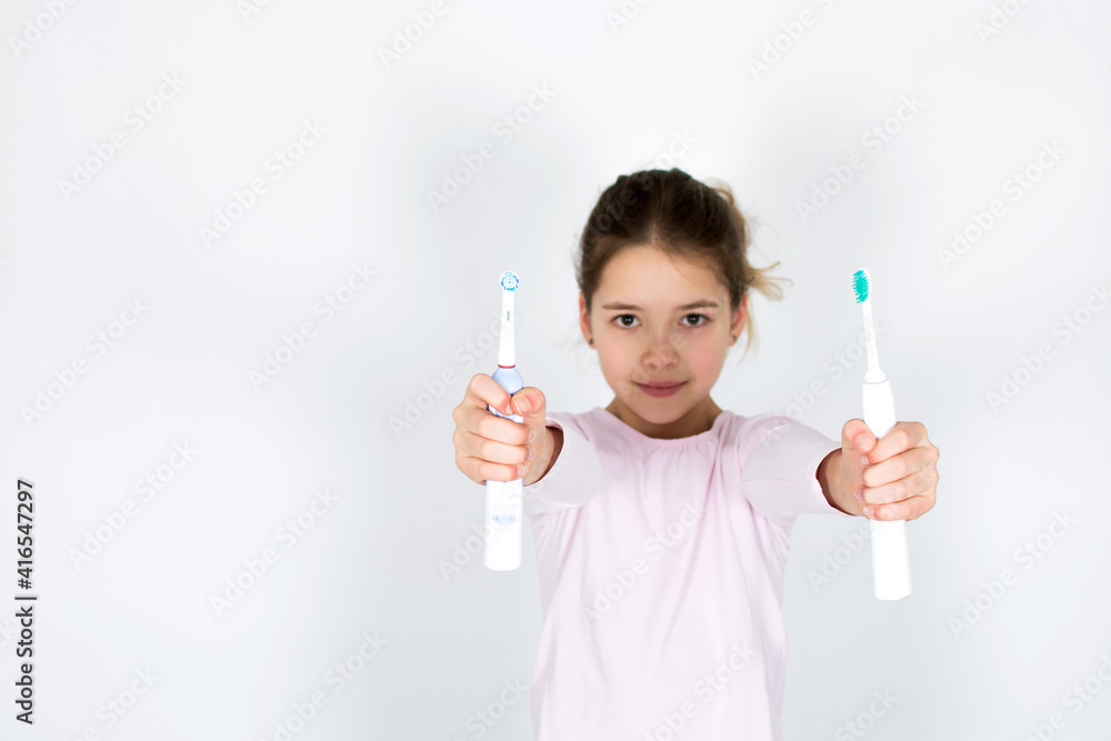 Child can´t decide between sonic and rotating oscillating toothbrush isotated on white background. Oral care and white teeth concept with copy space. Child can´t decide between sonic and rotating oscillating toothbrush isotated on white background. Oral care and white teeth concept with copy space.
