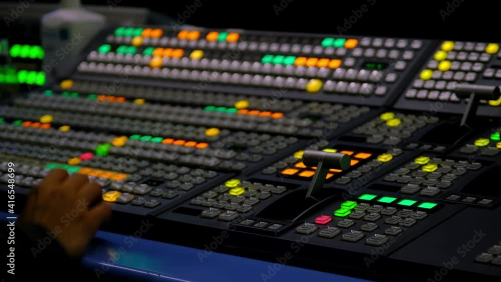 Broadcast Tv Studio Production - Vision Switcher Studio Director broadcast video mixer operation - Close-up of hand. Hands of a cinematographer who worked on the vision mixer, switch the TV panel. Broadcast Tv Studio Production - Vision Switcher Studio Director broadcast video mixer operation - Close-up of hand. Hands of a cinematographer who worked on the vision mixer, switch the TV panel.
