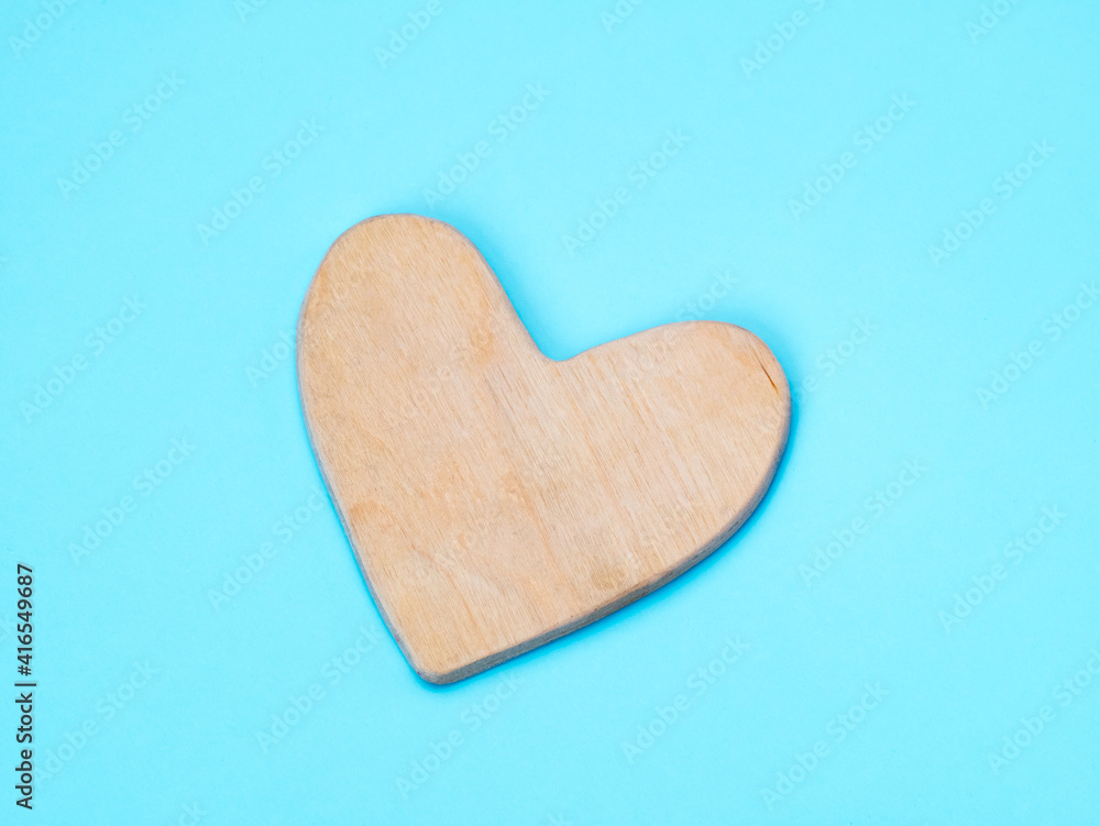 Wooden hand made heart on flat blue background Wooden hand made heart on flat blue background