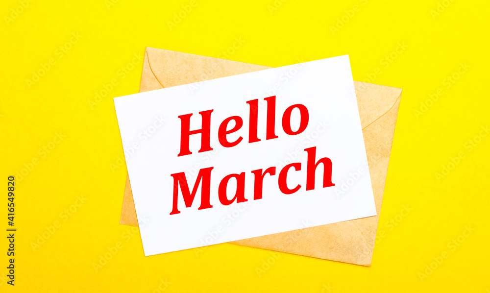 On a yellow background, an envelope and a card with the text HELLO MARCH. View from above On a yellow background, an envelope and a card with the text HELLO MARCH. View from above