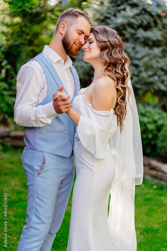 Walking newlyweds in the summer garden. wedding photo shoot in the park. Walking newlyweds in the summer garden. wedding photo shoot in the park.