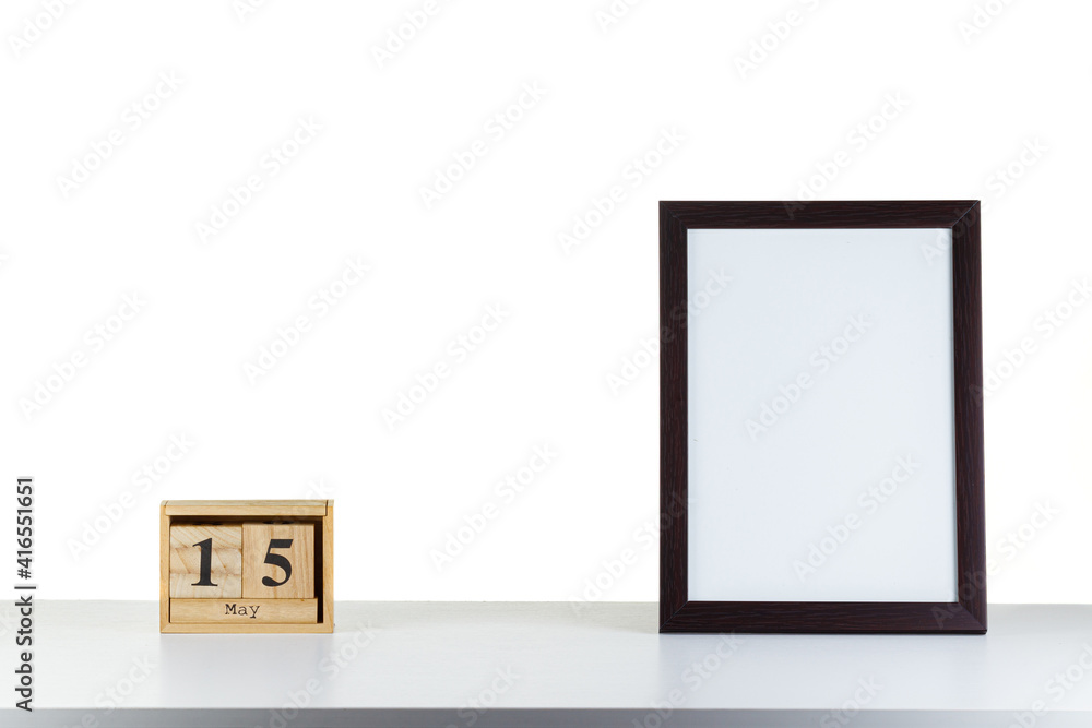 Wooden calendar 15 may with frame for photo on white table and background Wooden calendar 15 may with frame for photo on white table and background